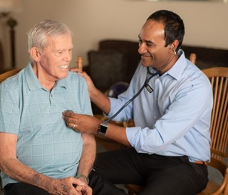 Dr Gobi Paramanandam listens to heart of patient in his home.